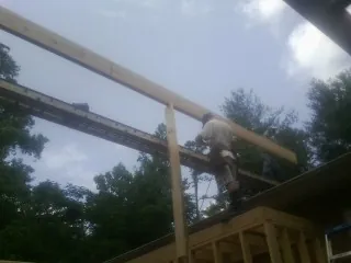 Carpenter setting a ridge beam over a new addition frame — Ice Dam Removal by Roofing Brothers in Levasy