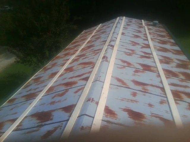 Rusted metal roof panels with new wood purlins before replacement — Storm Damage Roof Repair in Levasy by Roofing Brothers