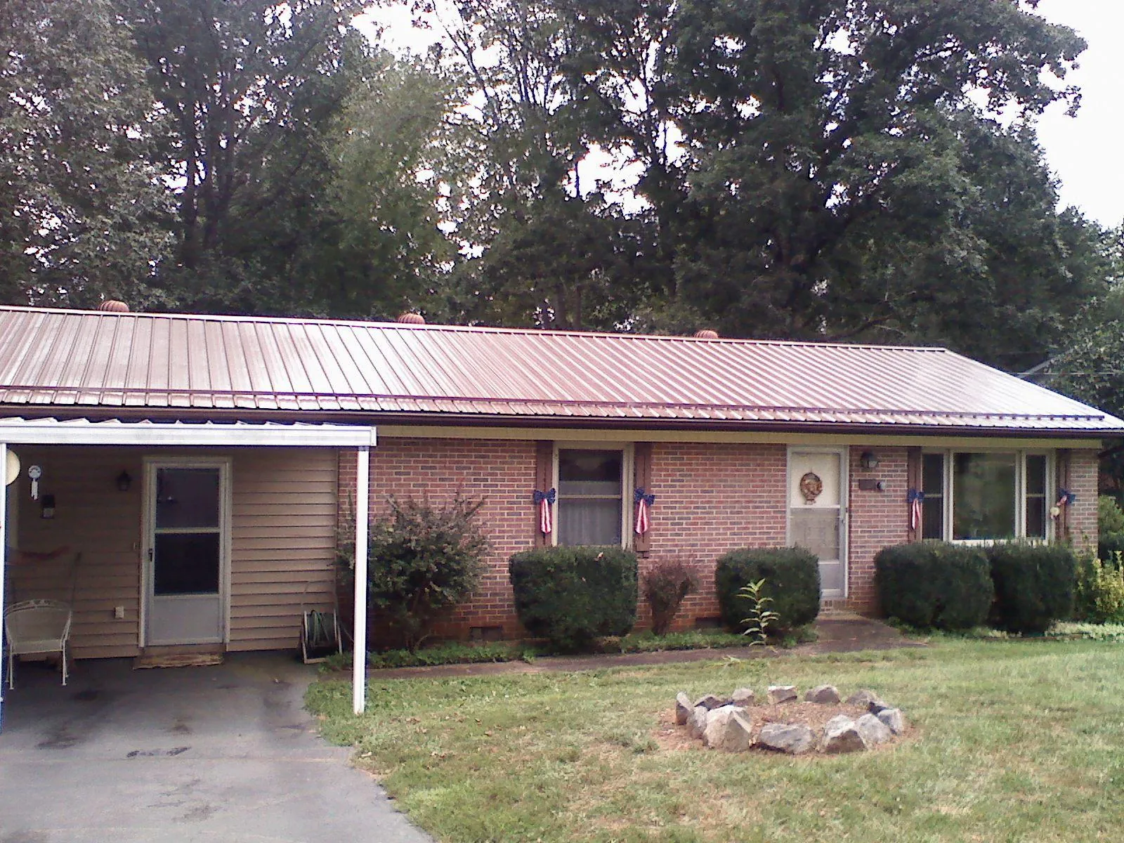 Bronze metal roof and carport on a brick ranch home — Roof Repair work by our crew in Levasy